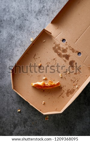 Pizza box with leftowers. Empty pizza cardboard box viewed from above. Top view. Royalty-Free Stock Photo #1209368095