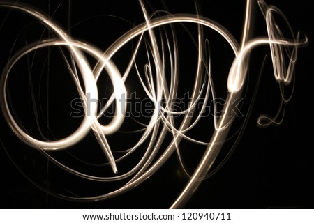 Abstract glowing background showing motion blurred neon light curves in gold