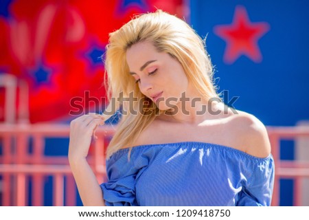 Portrait of a beautiful girl with blond hair on red and blue background with stars