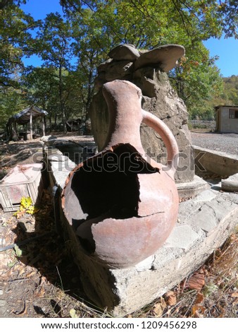 Broken earthenware jug standing at the well on the street