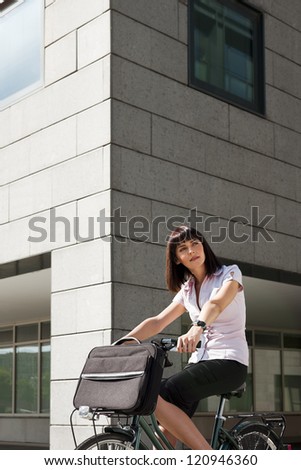mid adult caucasian business woman commuting to office by bike and looking away