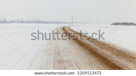 road in the winter season, snow-covered asphalt stripes visible from the tires of the car