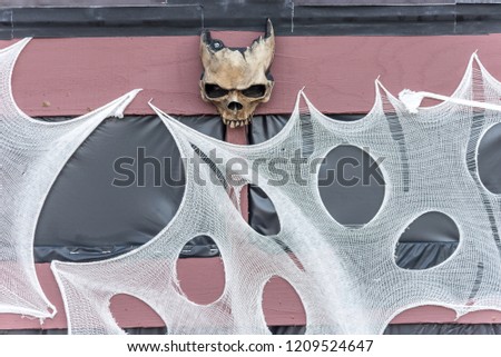 Creepy Halloween skull and spider webs on fence