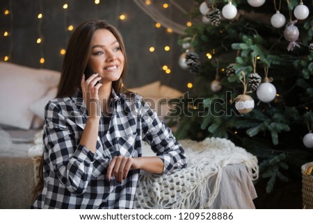 Красивая девушка пользуется телефоном в новый год