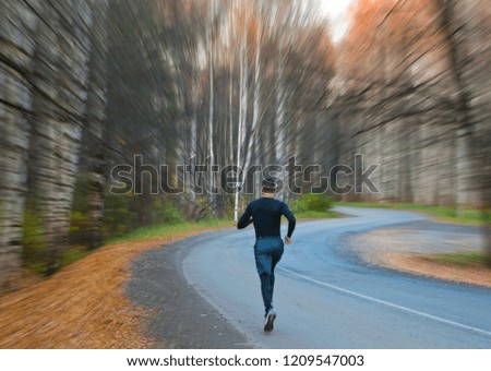  Runner on background of blurred zoom lens of autumn Park.