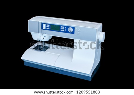 Full automatic sewing machine isolated on the dark background