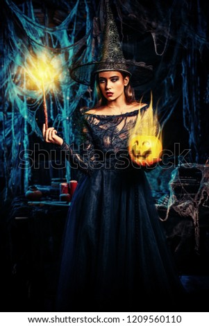 A witch in a castle holding a magic stick and a pumpkin. Halloween. Celebration.