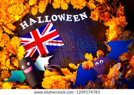 Union Jack surrounded with yellow oak leaves.  Halloween in UK. United Kingdom flag and the inscription Halloween. Toy bats. 