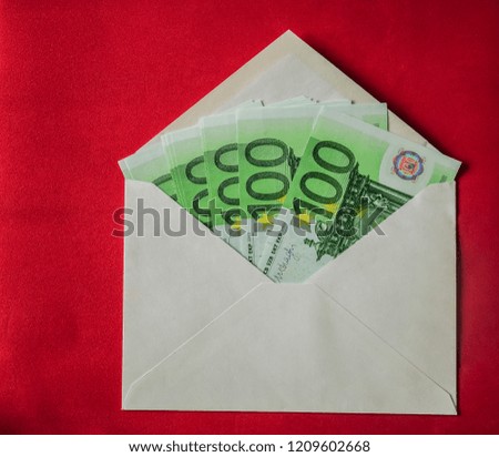 many 100 Euro Banknotes in envelope. opened white envelopes with cash. Salary payout or corruption concept. red background. 