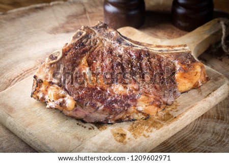 Juicy medium Beef steak on wooden board with herbs spices and salt. Close up