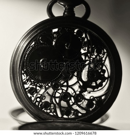 silhouette of gear wheel of vintage pocket watch, winter time and summer time concept 