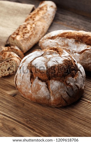 Different kinds of bread and bread rolls on board from above. Kitchen or bakery poster design.