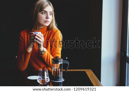 Cafe city lifestyle - young beautiful woman drinking from a cup in trendy urban cafe