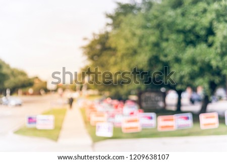 Vintage tone motion blurred people walking on residential street near yard sign at for primary election day in Dallas, Texas, USA. Signs greeting early voters.