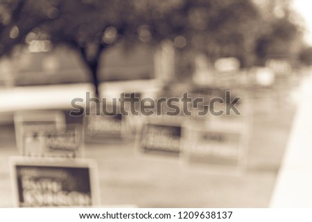 Vintage tone blurred row of yard signs at residential street for primary election day in Dallas county, Texas, US. Signs greeting early voters, political party posters for the midterm election concept