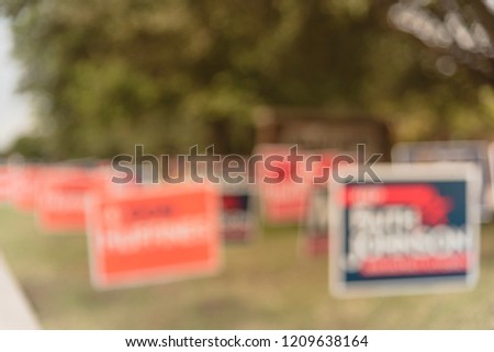 Blurred image row of yard sign at residential street for primary election day in Dallas county, Texas, USA. Signs greeting early voters, political party posters for the midterm election concept