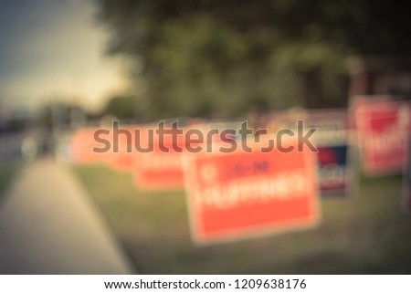 Blurred image row of yard sign at residential street for primary election day in Dallas county, Texas, USA. Signs greeting early voters, political party posters for the midterm election concept