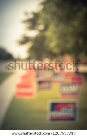 Blurred image row of yard sign at residential street for primary election day in Dallas county, Texas, USA. Signs greeting early voters, political party posters for the midterm election concept