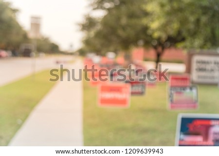 Blurred image row of yard sign at residential street for primary election day in Dallas county, Texas, USA. Signs greeting early voters, political party posters for the midterm election concept