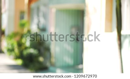 Defocused shot of rustic wood door and tropical shrubs at apartment entrance