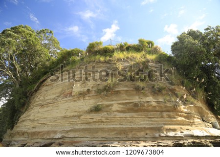 Side of a cliff with the sky.  Taken at cockle bay Auckland, New Zealand. Royalty-Free Stock Photo #1209673804