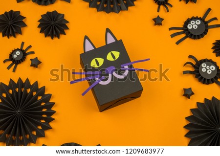 Orange background with collection of Halloween objects overhead view. Black cat, spider, bat, witch, feared party decor. Handwork.
