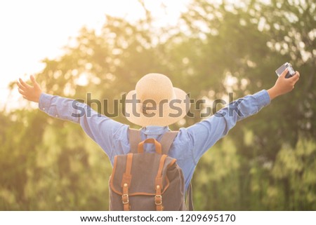 Asian woman photographer raise up hand freedom and enjoy view at sunset