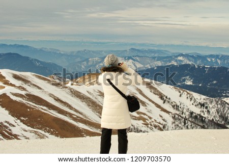  Girl takes a picture of the smartphone of the mountain