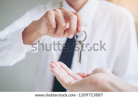 Sale agent giving house keys to customer and sign agreement contract, Insurance Home concept