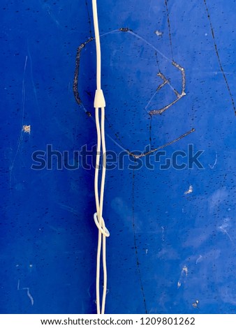 Earphone cables on a blue sign