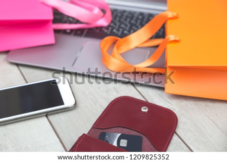 Shopping bags, credit card, laptop on desk