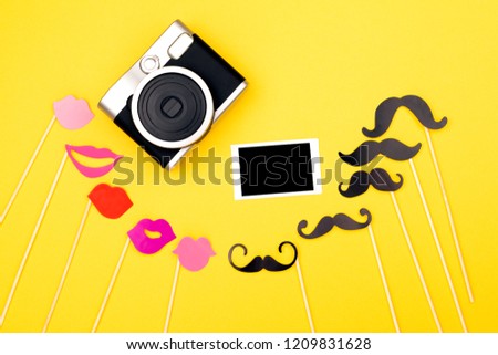 Photo booth props, blank photo frame mock-up, instant camera on the yellow background. Wedding, party or Birthday background. Flat-lay, top view.