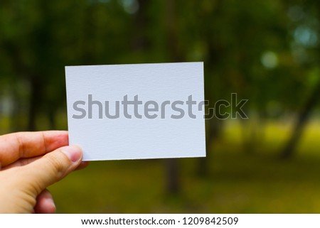 white blank business card in hand outdoors