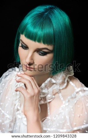 Young woman with green hair. Bizarre green hair girl. Creative haircut.