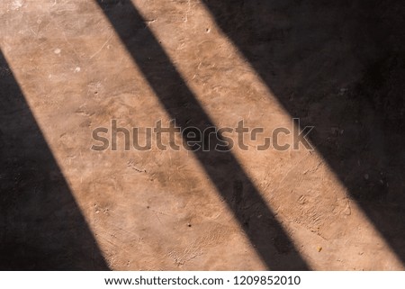 Sunlight lines on a cement floor.