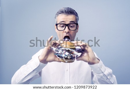 Greedy nerd IT technology enthusiast eating a sandwich filled with hardware and computer parts