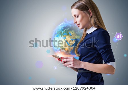 Side view of blonde businesswoman with smartphone standing near gray wall with earth hologram and internet icons. Toned image Elements of this image furnished by NASA