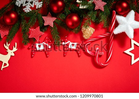 beautiful Christmas baubles, spruce, stars and wooden horses on a red background