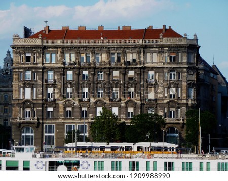 Budapest the popular travel destination. Traditional residential mid-rise building frontal elevation in Budapest, with roof balustrade, vertical wooden windows & decorated stucco exterior finish