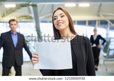 Business woman with a blank welcome sign at the airport terminal for a guest