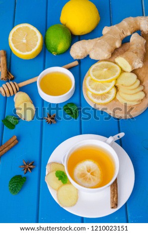 Ginger tea with lemon and honey on blue wooden background