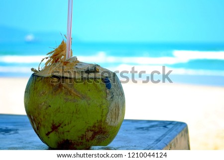 Coconut drink on a table in Danang Vietnam, South China sea in the background