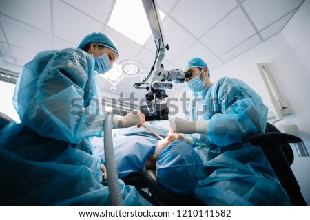 Dentist during a dental intervention with a patient. Dental clinic concept. Royalty-Free Stock Photo #1210141582