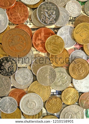 Close up top view image of large amount of old money coins of different countries and times on dollars usa background