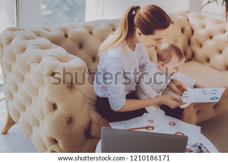 New project. Corporate remote worker feeling engaged in new business project while nursing her sweet child sitting at home