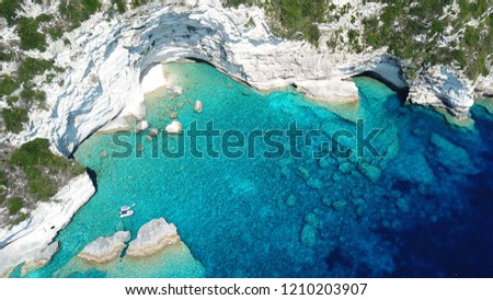 Aerial drone bird's eye view photo of sail boats docked in tropical paradise bay with white rock caves and turquoise clear sea located in Thailand