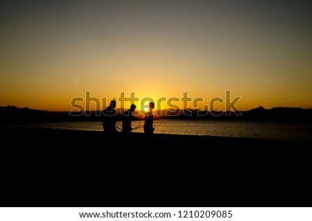 three men silhouette on the lagoon at sunset, lagoa de imboassica, macae, rio de janeiro, brazil                                    