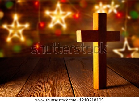 Christian wood cross on Christmas stars wooden background