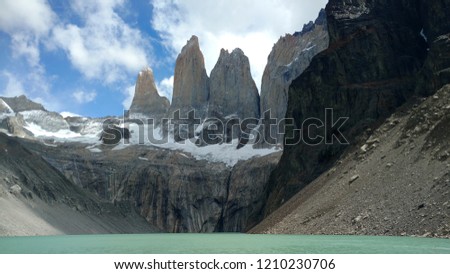 A Towers of Paine picture. A lake with rocks and snow in the background. A trekking trip.
