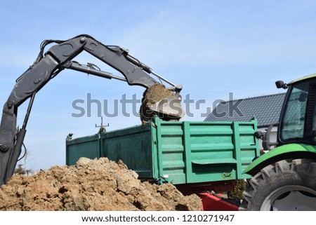 trailer filled with soil and clay using an excavator